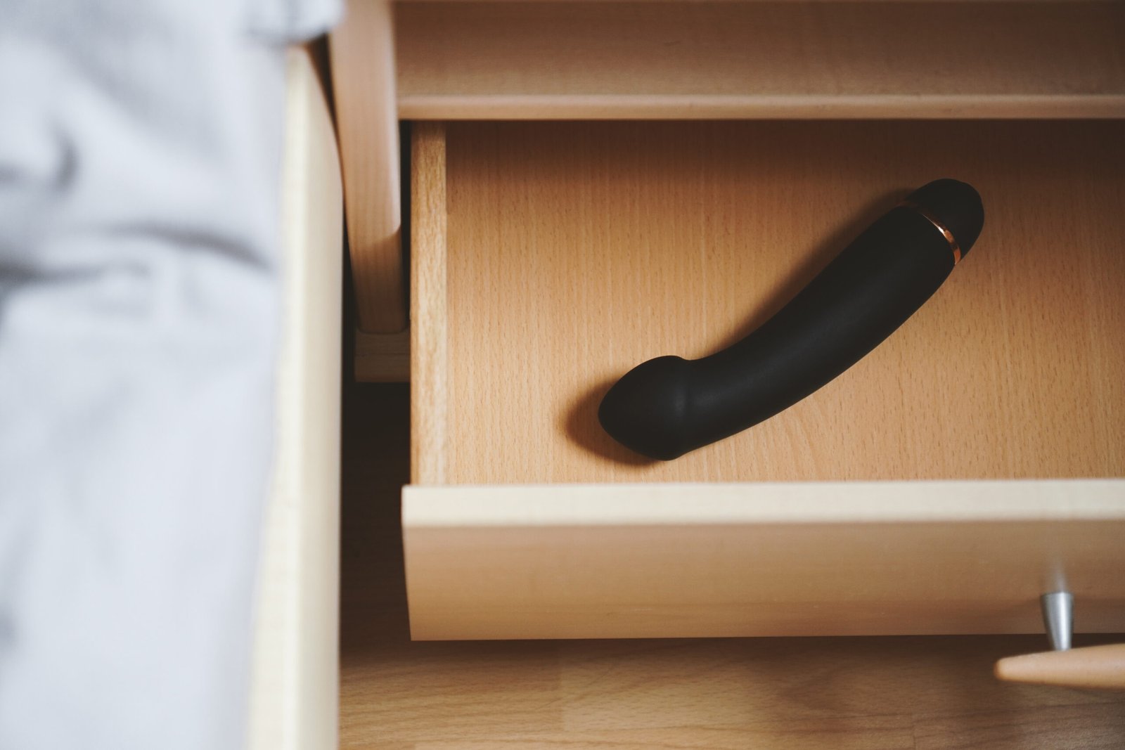 vibrator sex toy ready in bedside table or nightstand drawer